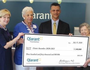Qlarant Associates and Board Members holding a large check for $340,000